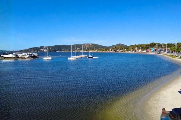 Vista da Lagoa da Conceição em Florianópolis, com paisagem e água calma.